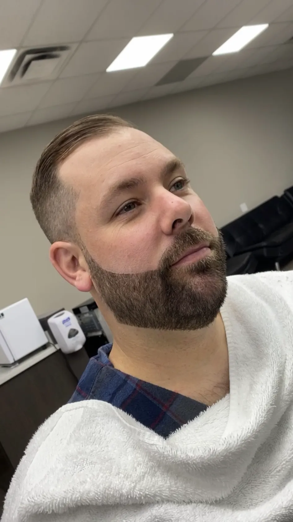 Side part with a tapered fade and full beard